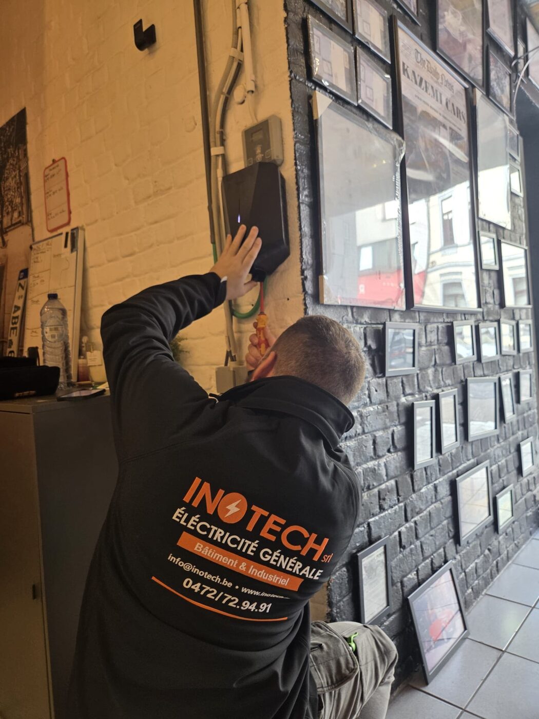 Technicien Inotech installation prise mur briques